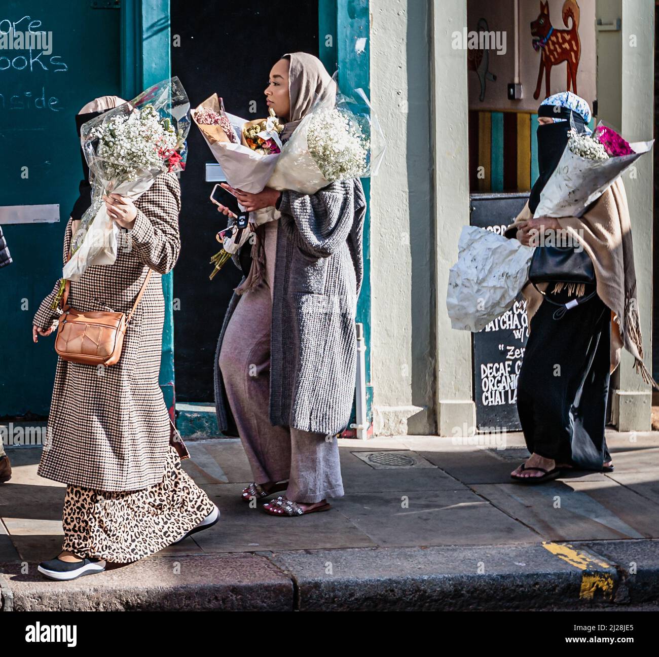 Muslim ladies carry their flowers in east London. Stock Photo