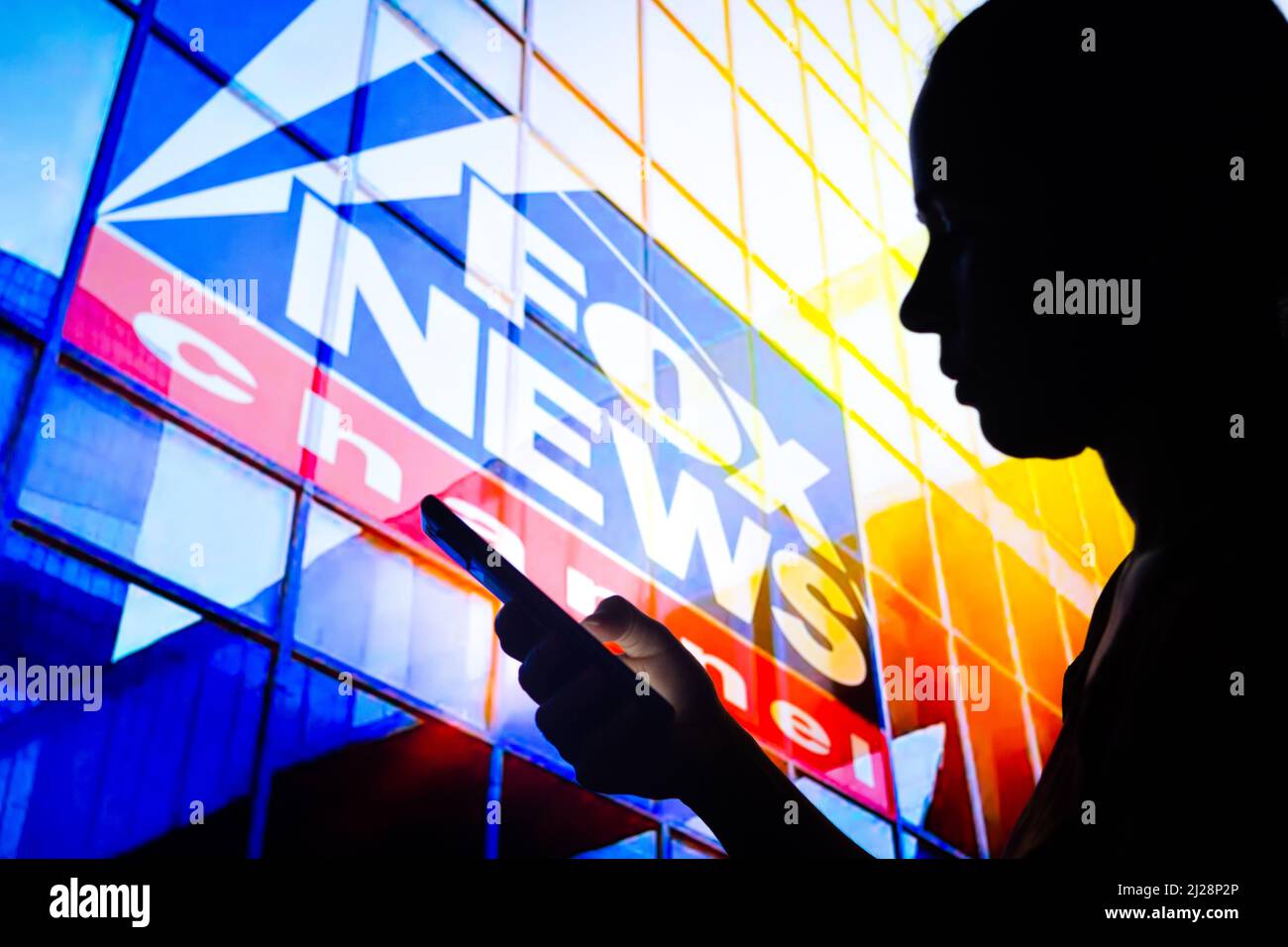 Brazil. 30th Mar, 2022. In this photo illustration, a woman's silhouette holds a smartphone with the Fox News Channel logo in the background. Credit: SOPA Images Limited/Alamy Live News Stock Photo