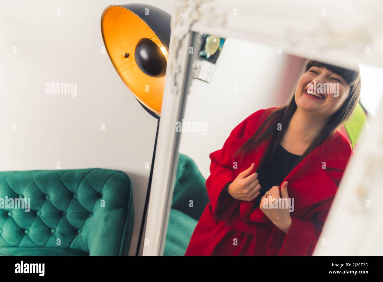 Mirror reflection of a beautiful caucasian brown-haired woman smiling and laughing during clothes shopping. . High quality photo Stock Photo