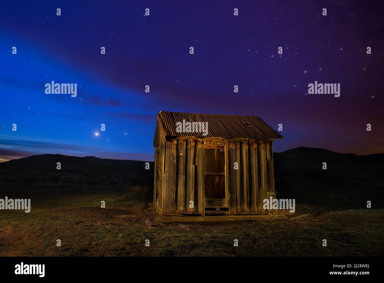 Small abandoned shack in the high desert of Lassen County, California, USA.  Photographed at twilight showing Venus, Saturn, and Mars rising. Stock Photo