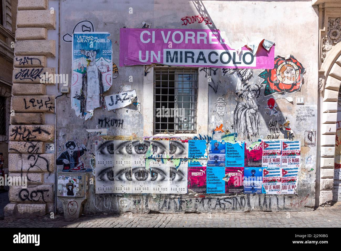 Rome, Italy - August 3, 2021: typical murals and poster at a house wall in roman quarter Trastevere. Stock Photo