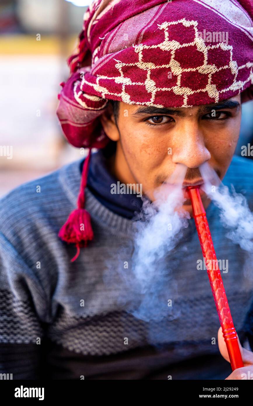 A Portrait Of A Young Man Smoking A Shisha Pipe, Petra, Jordan, Asia. Stock Photo