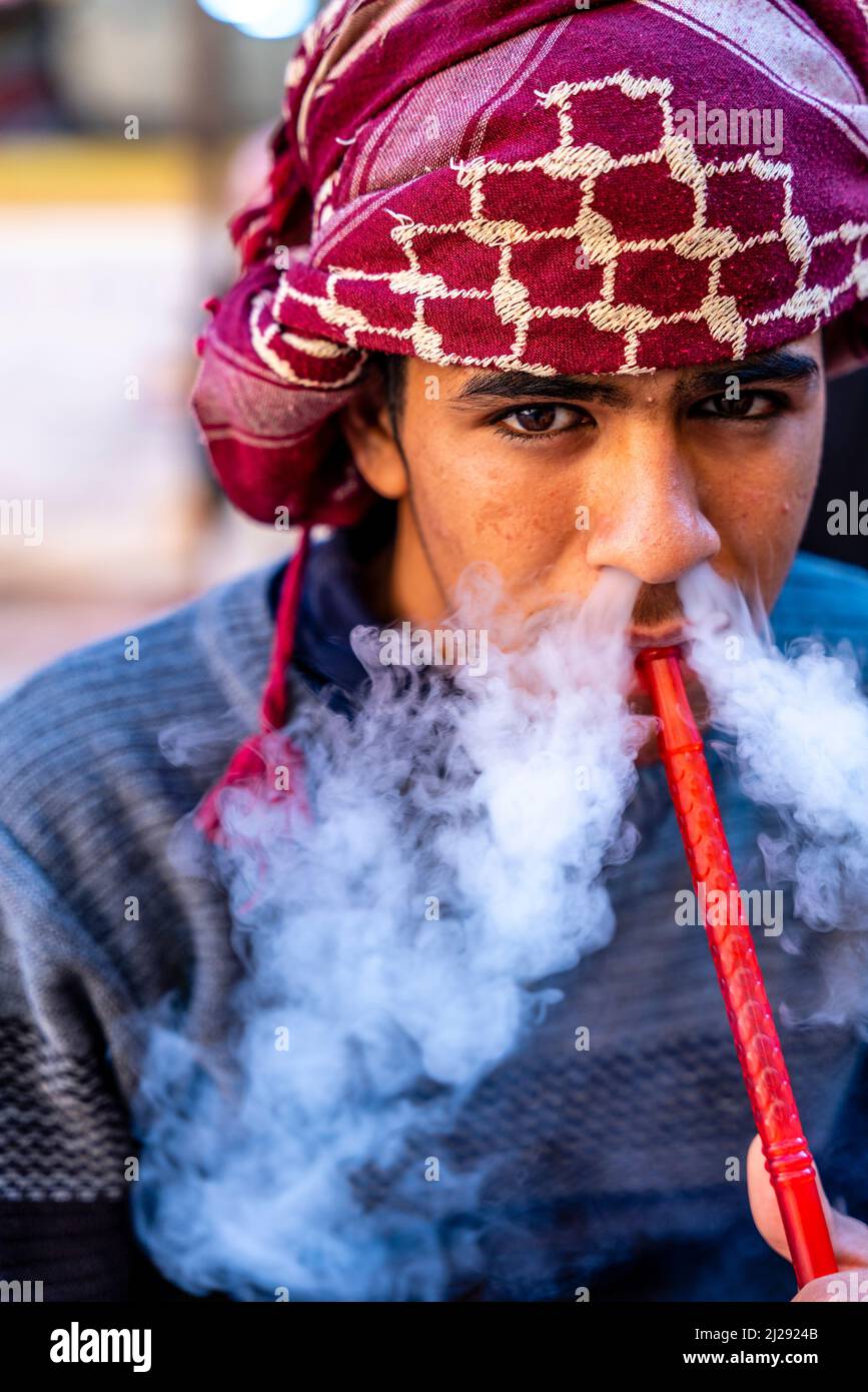 A Portrait Of A Young Man Smoking A Shisha Pipe, Petra, Jordan, Asia. Stock Photo