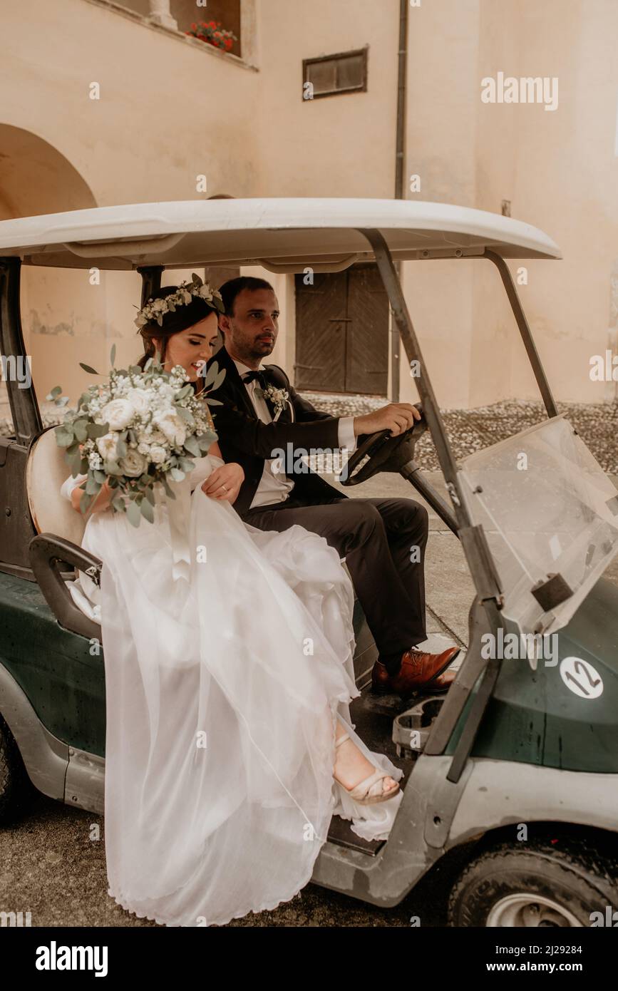 The bride and the groom riding in golf card at wedding reception Stock ...