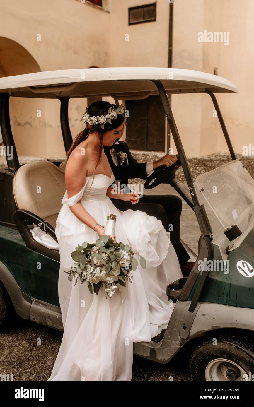The bride and the groom riding in golf card at wedding reception Stock ...