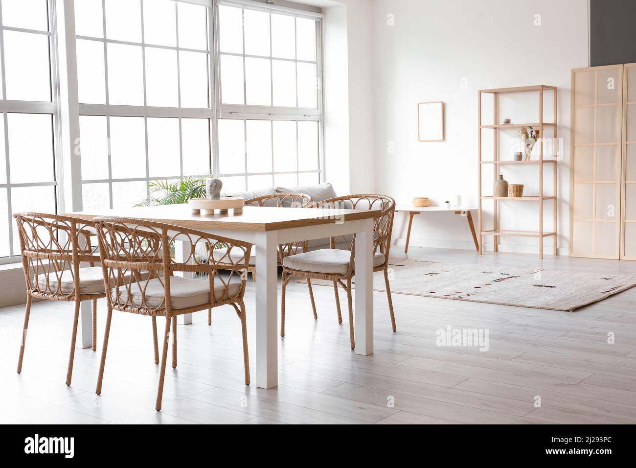 Interior of light dining room with table, sofa and shelving unit Stock ...