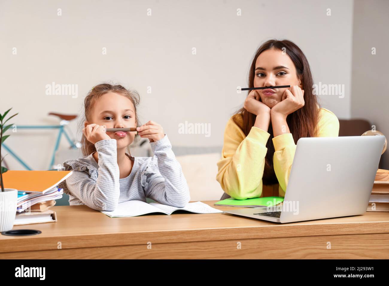 Little girl with tutor having fun during studying at home Stock Photo ...