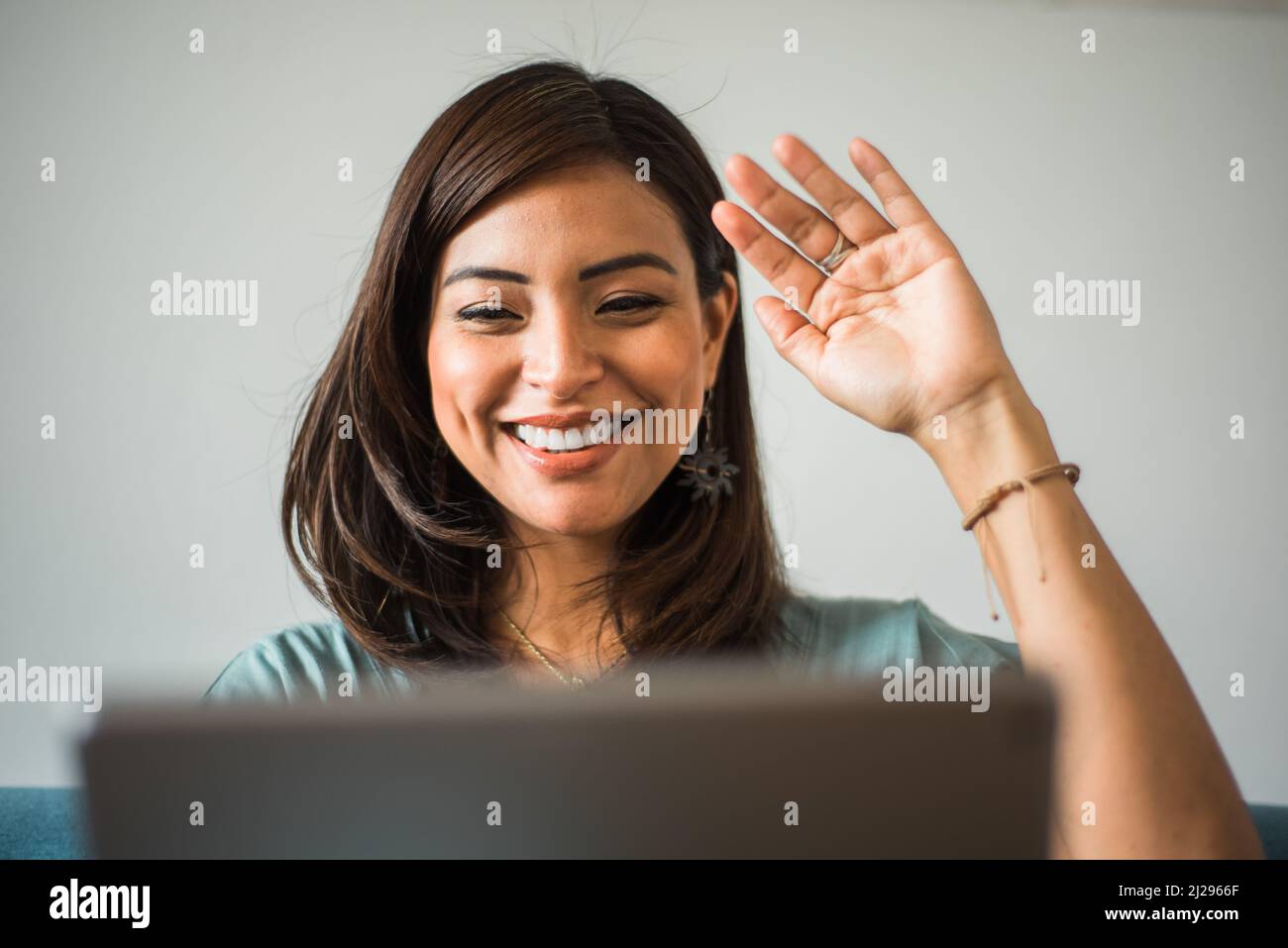 Close Up Of Latina Teacher Greeting Her Class On A Video Call At Home