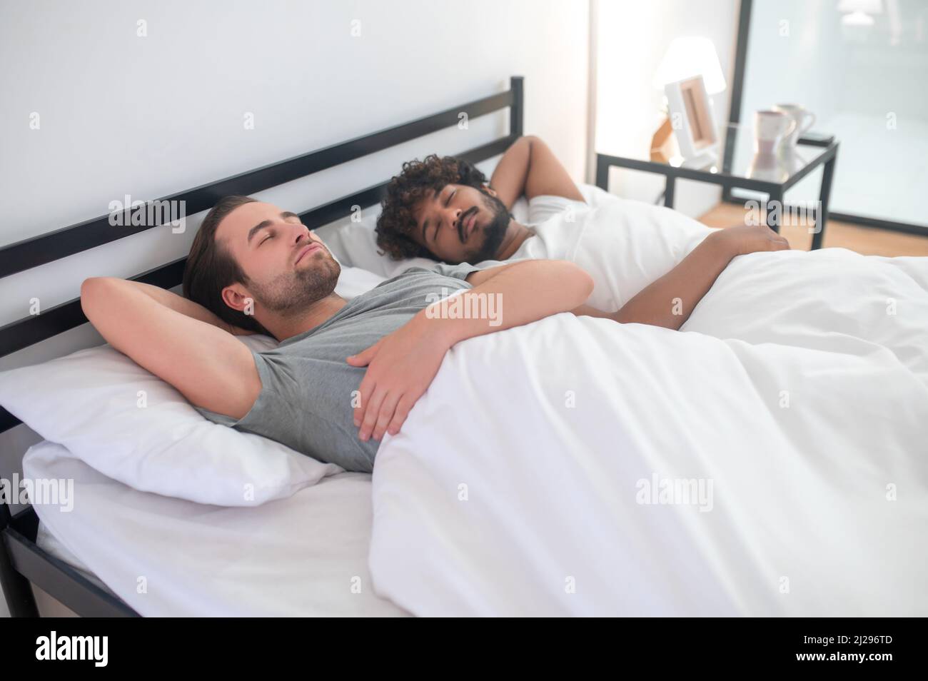 Two gay men napping in their bedroom Stock Photo