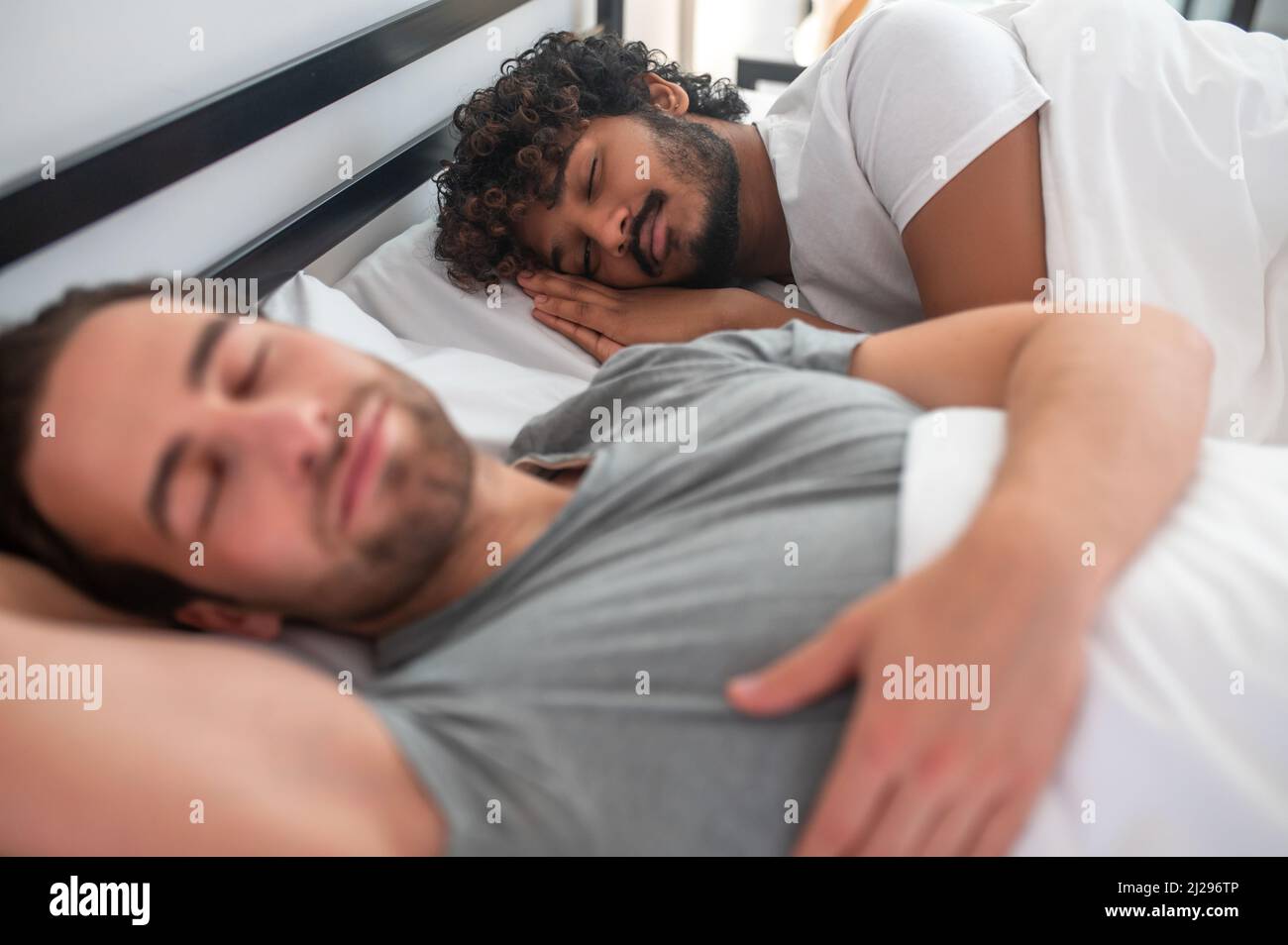 Gay couple lying taking a nap in their bedroom Stock Photo