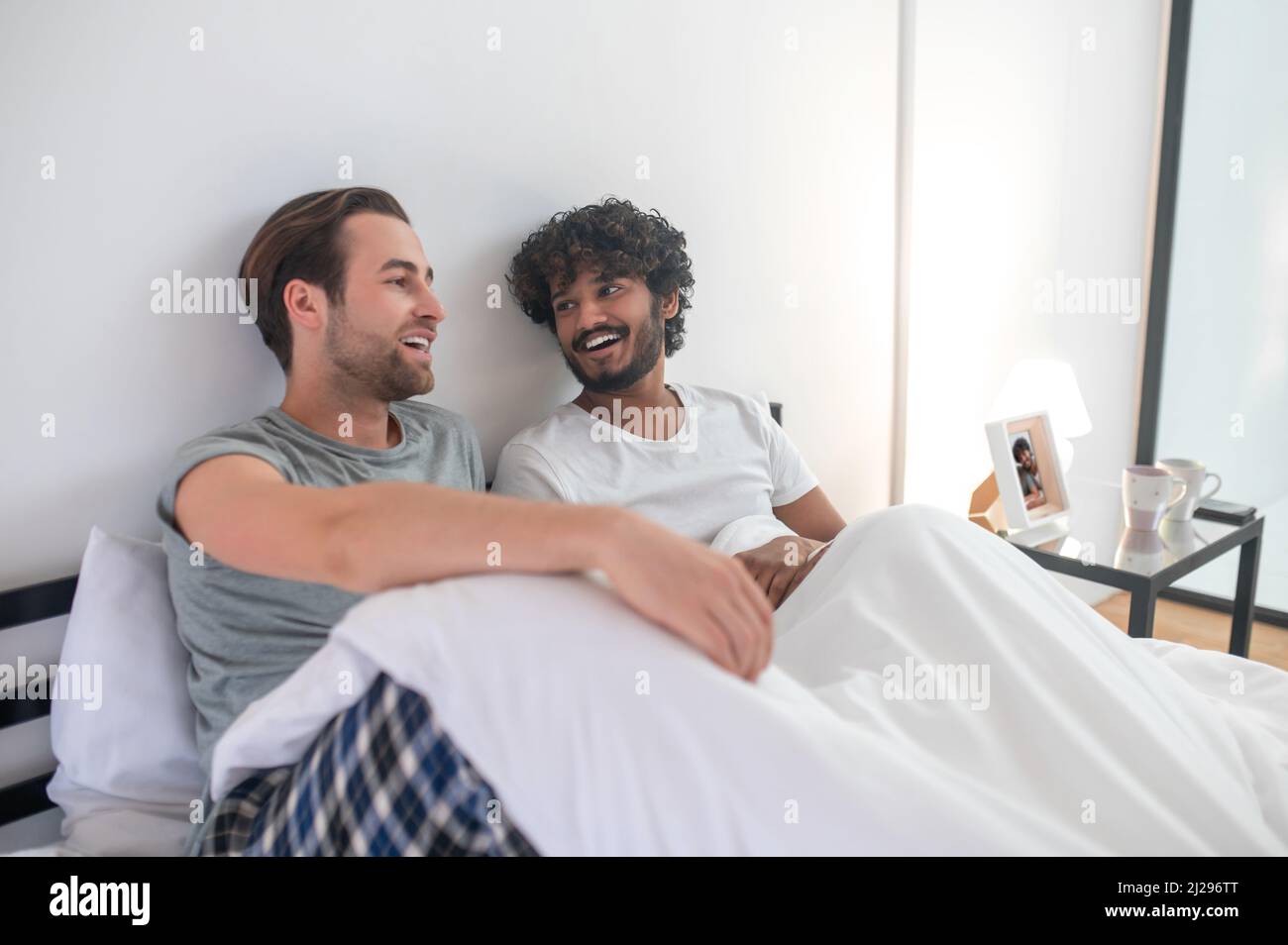 Gay couple having a talk in the bedroom Stock Photo