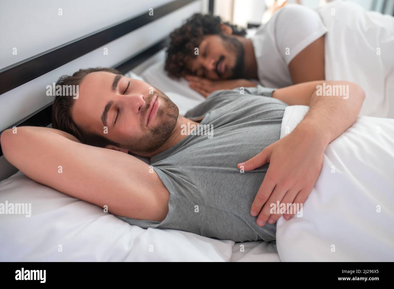 Gay couple lying in bed during the morning sleep Stock Photo