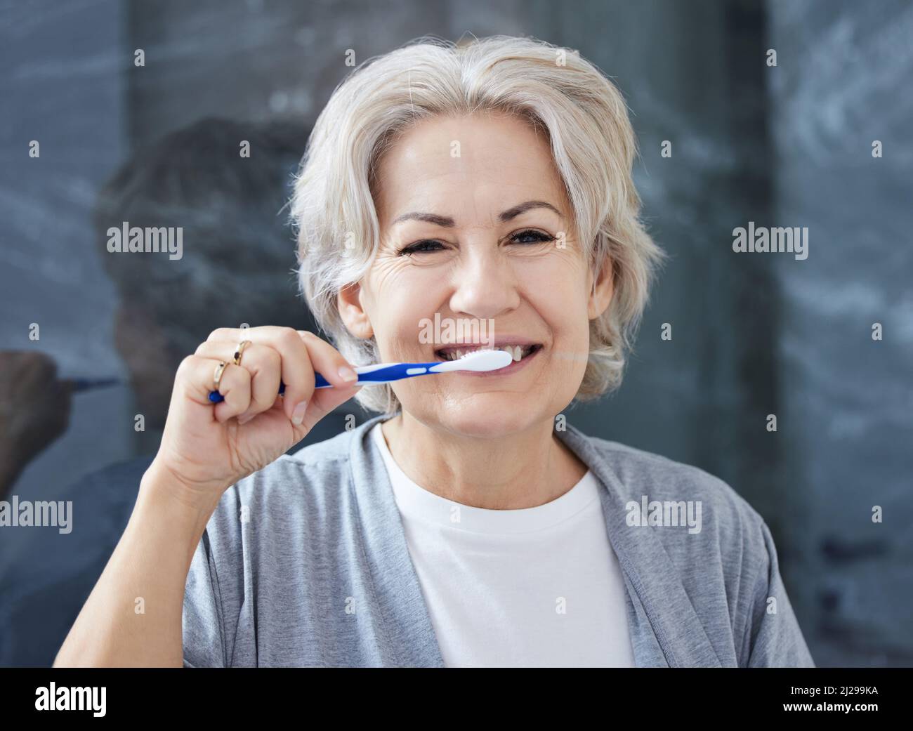 I still have all my teeth because I take good care of it. Shot of a senior woman brushing her teeth at home. Stock Photo