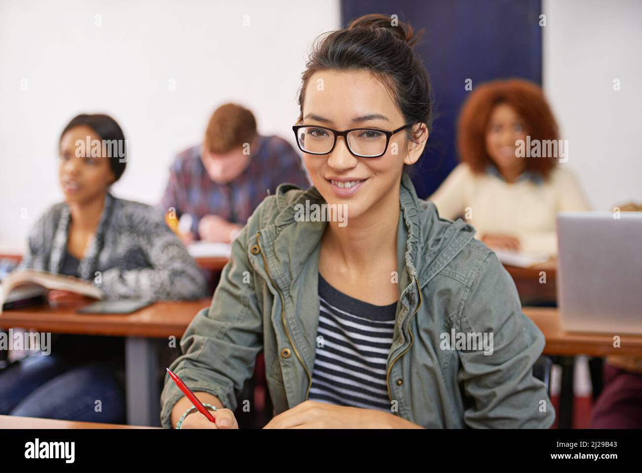 A solid education for a promising future. Portrait shot of a happy female student sitting at her desk. Stock Photo