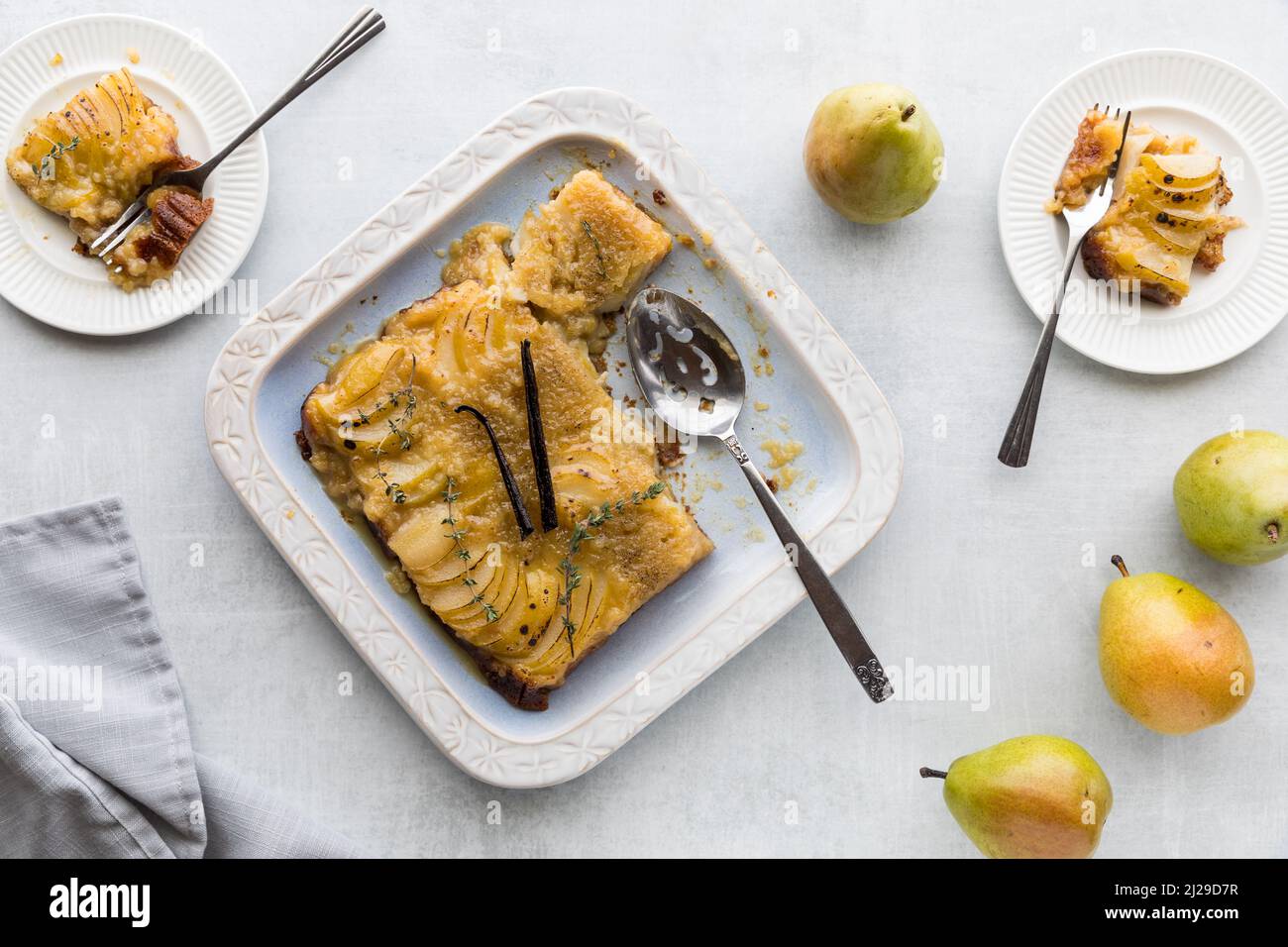 Delicious pear upside down cake garnished with vanilla pods and thyme. Stock Photo