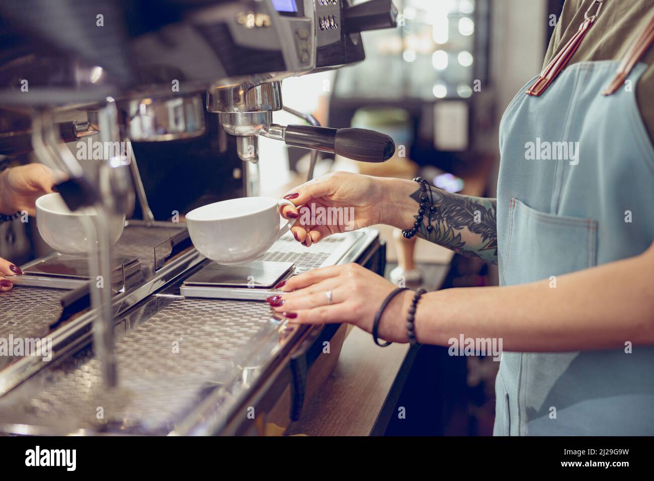 Barista using professional coffee machine in coffeehouse Stock Photo