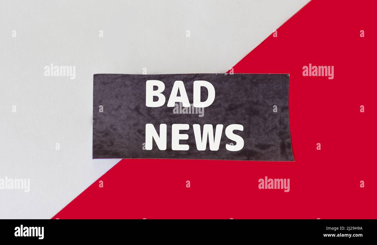Bad news,text on black sticky note and red and white background. Stock Photo
