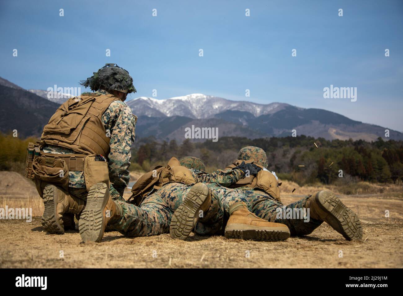 U.S. Marine Corps Sgt. Troy Williams, a semitrailer refueler operator with Marine Wing Support Squadron (MWSS) 171, oversees Marines shooting an M249 light machine gun at Japan Ground Self-Defense Force Camp Nihonbara, Japan, March 10, 2022. Marines and Sailors with MWSS-171 and Marine Air Control Squadron 4 participated in Exercise Tanuki Wrath 2022 to enhance their skills in setting up a forward operating base, establishing a forward arming and refueling point, and conducting live-fire weapons training.  (U.S. Marine Corps photo by Lance Cpl. Calah Thompson) Stock Photo