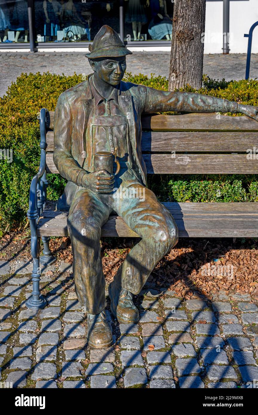 Bronze figure, Bavarian with beer mug on wooden bench, Immenstadt, Allgaeu, Bavaria, Germany Stock Photo