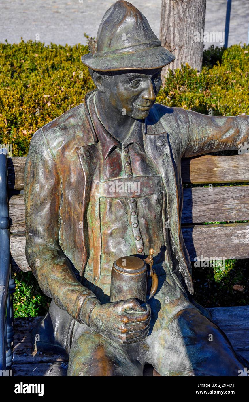 Bronze figure, Bavarian with beer mug on wooden bench, Immenstadt, Allgaeu, Bavaria, Germany Stock Photo