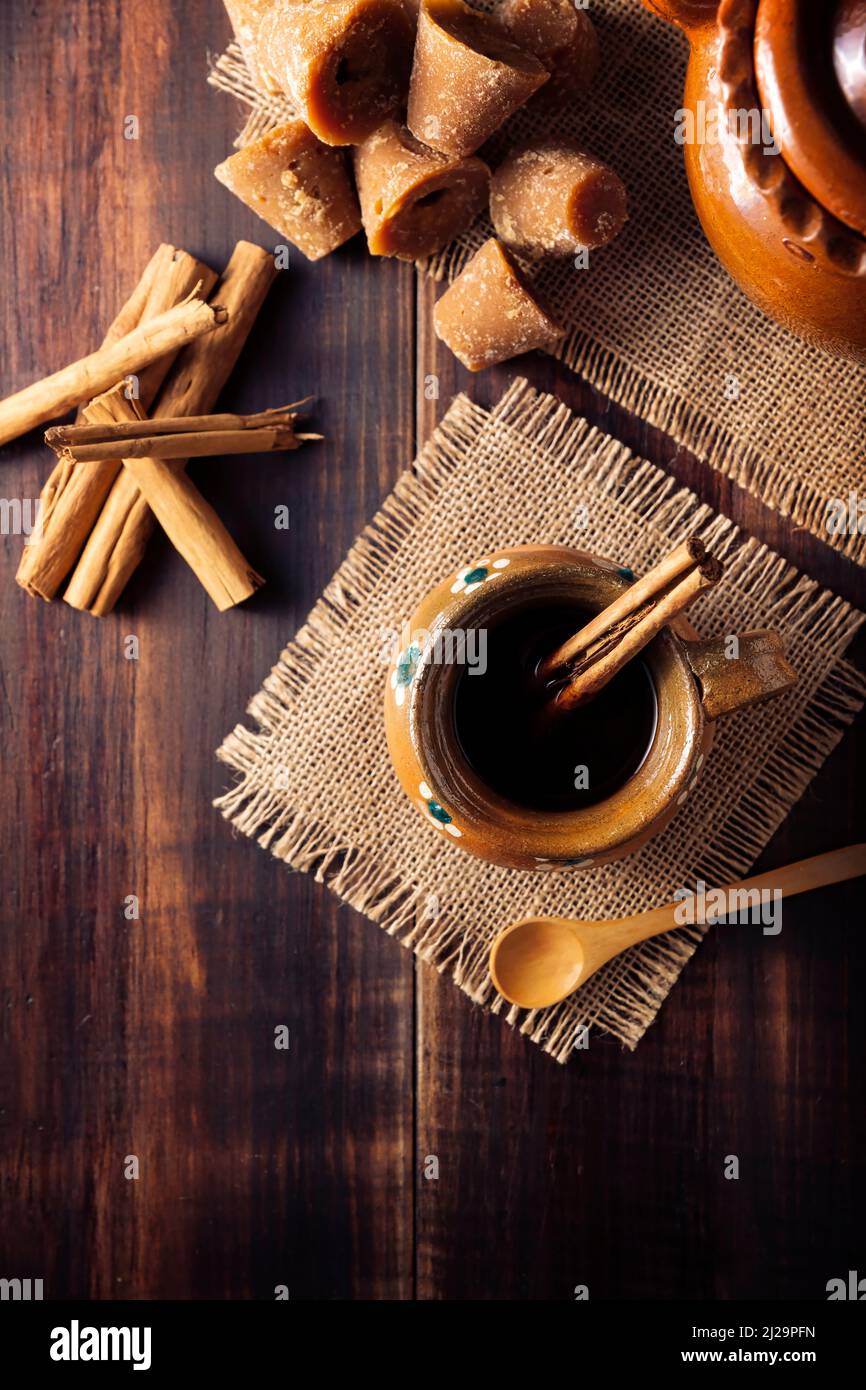 Cafe de Olla. Traditional Mexican coffee and basic ingredients for its preparation, coffee, cinnamon and piloncillo, served in a clay cup called 'jarr Stock Photo