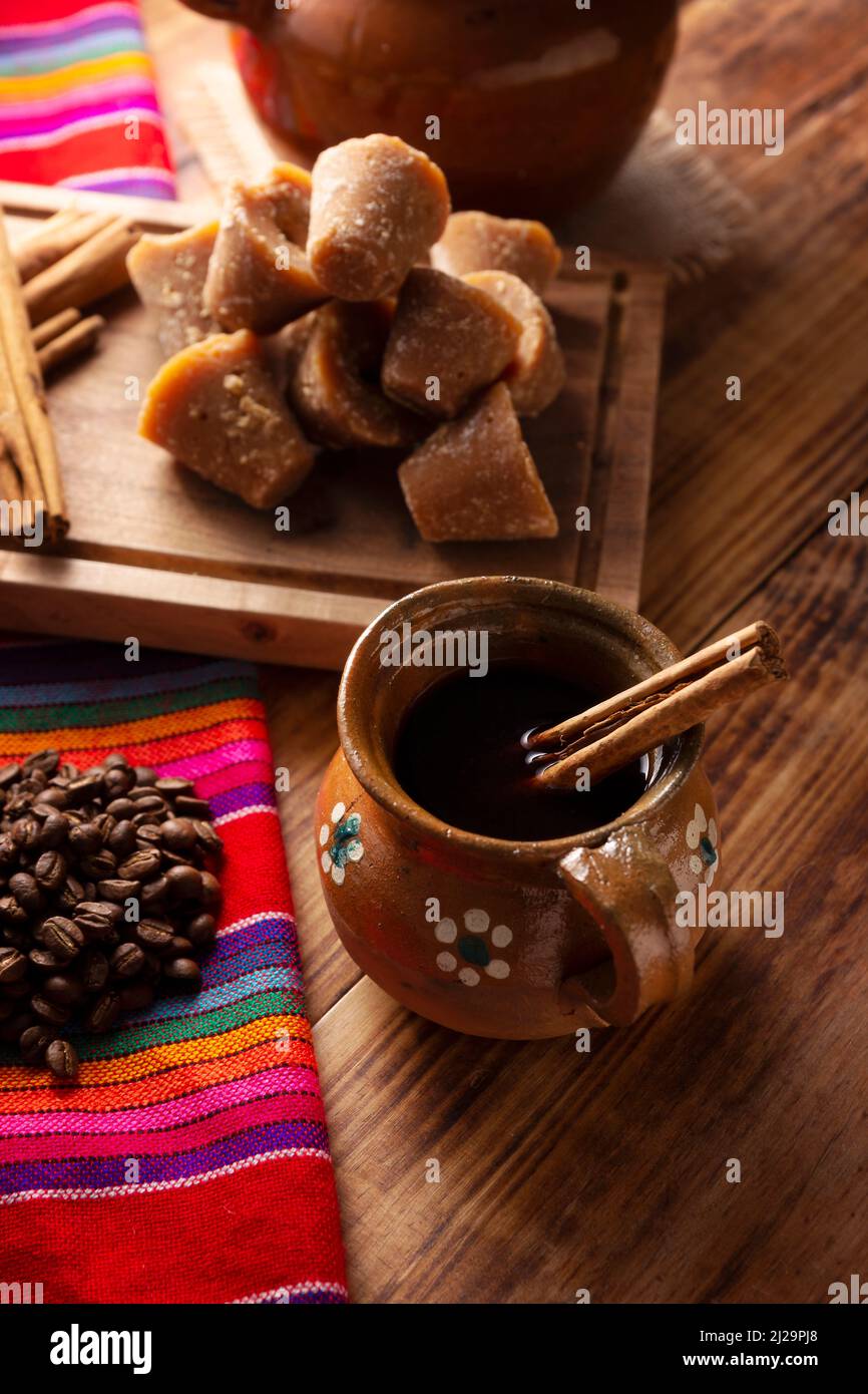 Cafe de Olla. Traditional Mexican coffee and basic ingredients for its preparation, coffee, cinnamon and piloncillo, served in a clay cup called 'jarr Stock Photo