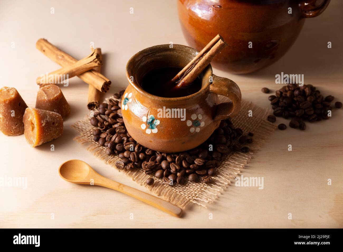 Cafe de Olla. Traditional Mexican coffee and basic ingredients for its preparation, coffee, cinnamon and piloncillo, served in a clay cup called 'jarr Stock Photo