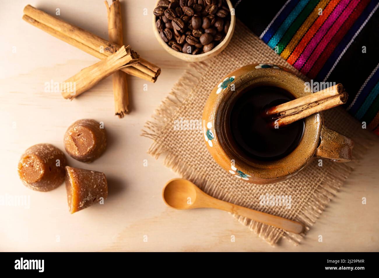 Cafe de Olla. Traditional Mexican coffee and basic ingredients for its preparation, coffee, cinnamon and piloncillo, served in a clay cup called 'jarr Stock Photo