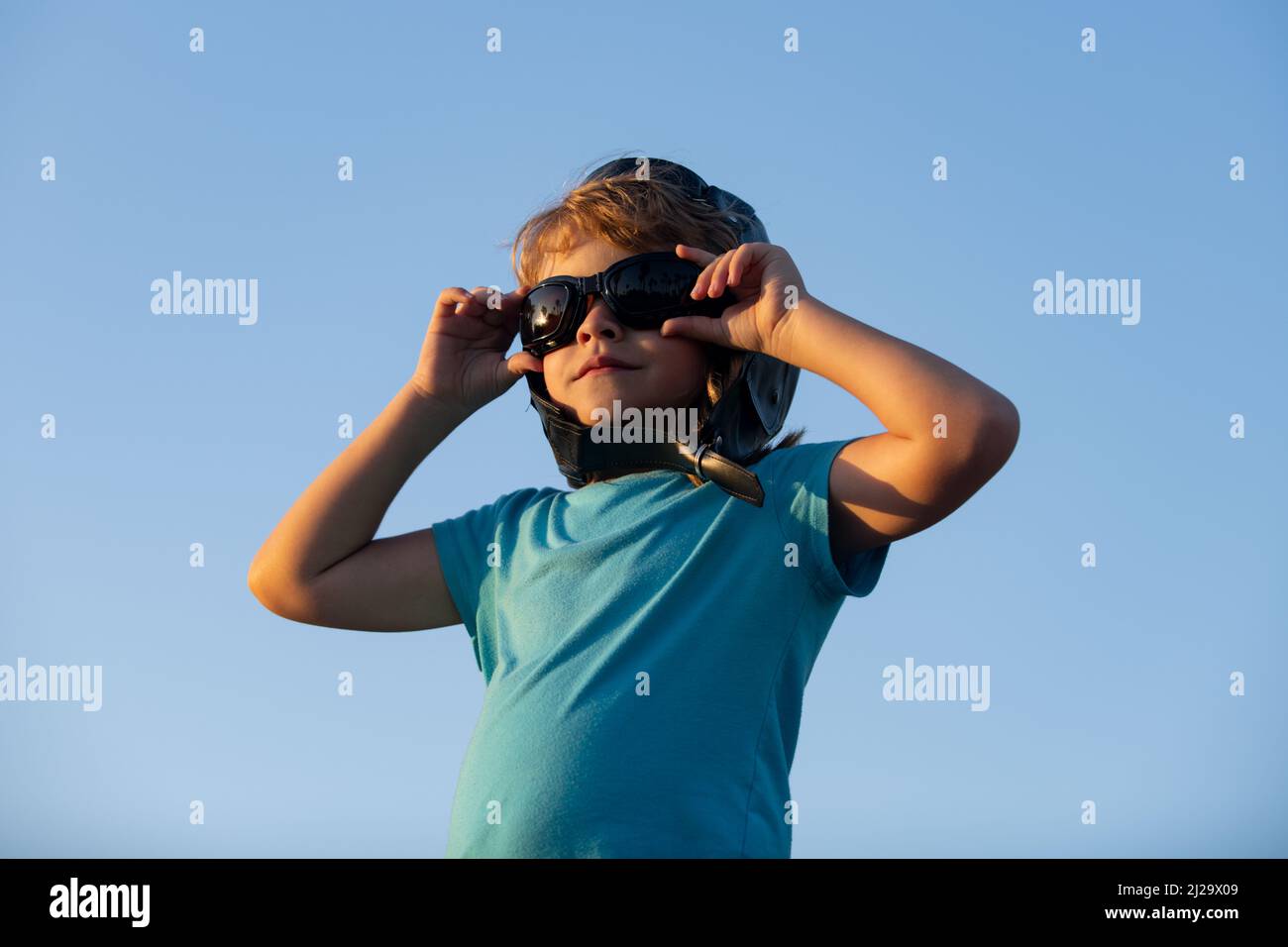 Child boy playing with pilot goggles and helmet, dream of a