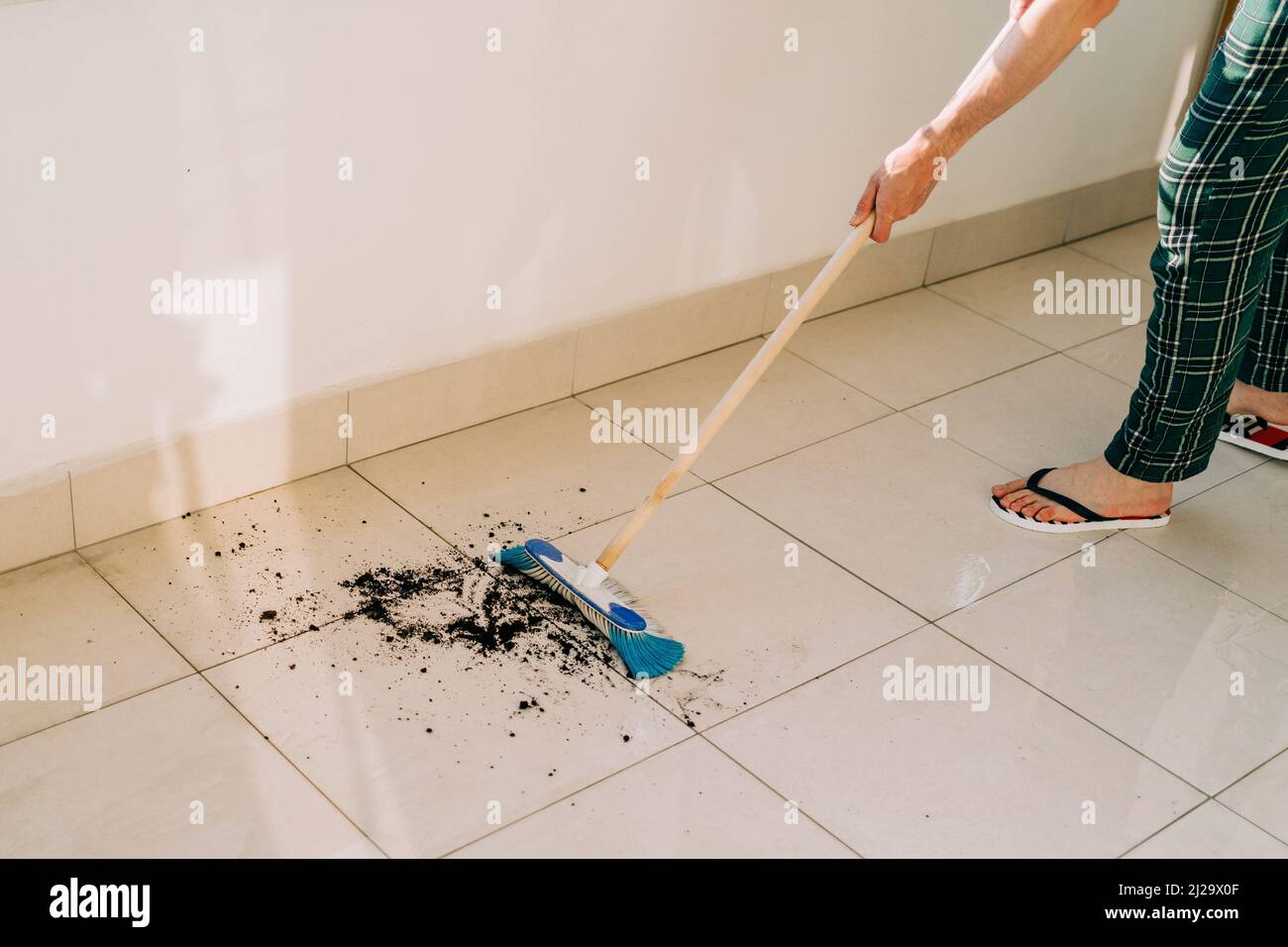 Man wiping floor with the mop. Janitor washing the dirty floors. Guy