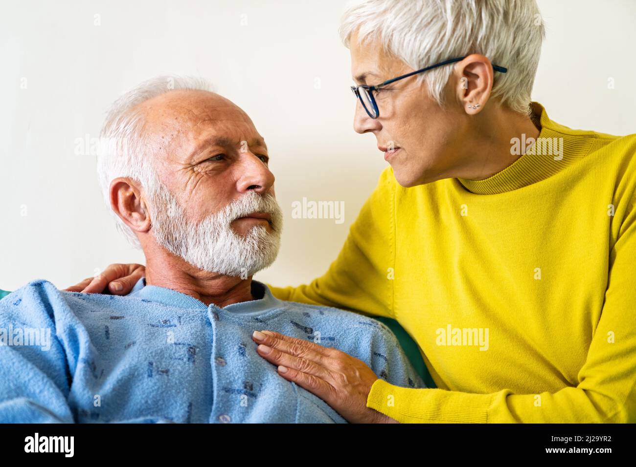 Medicine, support, healthcare and people concept. Senior woman visiting her sick husband in hospital Stock Photo