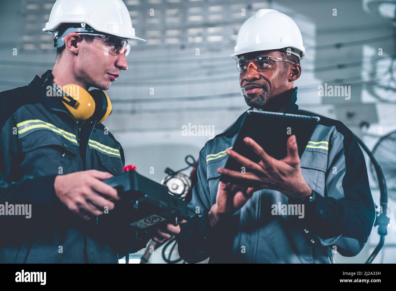 Group of factory job workers using adept machine equipment in a