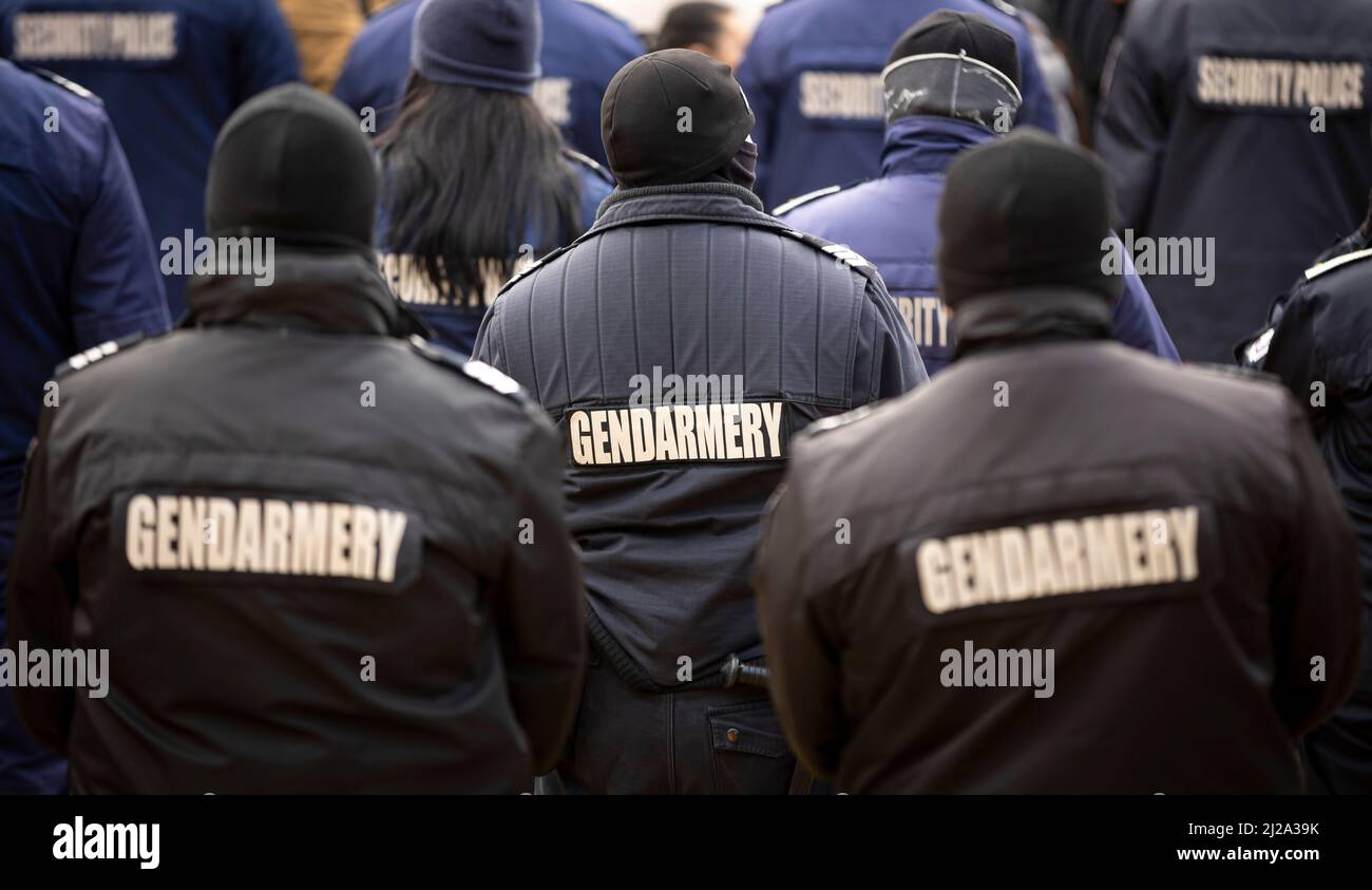 Police officers are seen from their backs. Unrecognizable policemen and policewomen. Gendarmery. Stock Photo