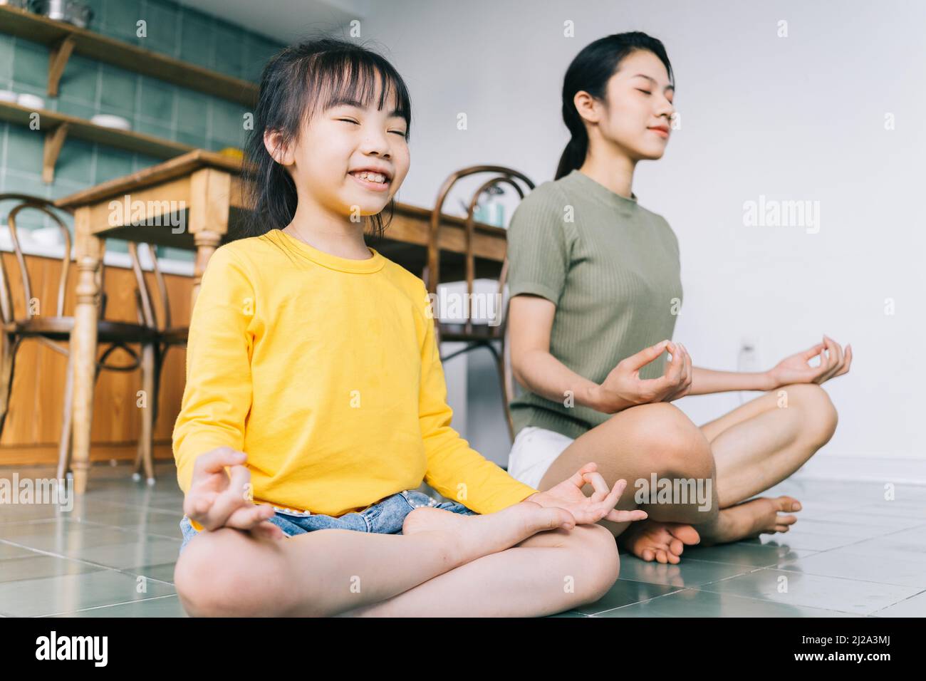 Mother and daughter doing yoga at home Stock Photo - Alamy