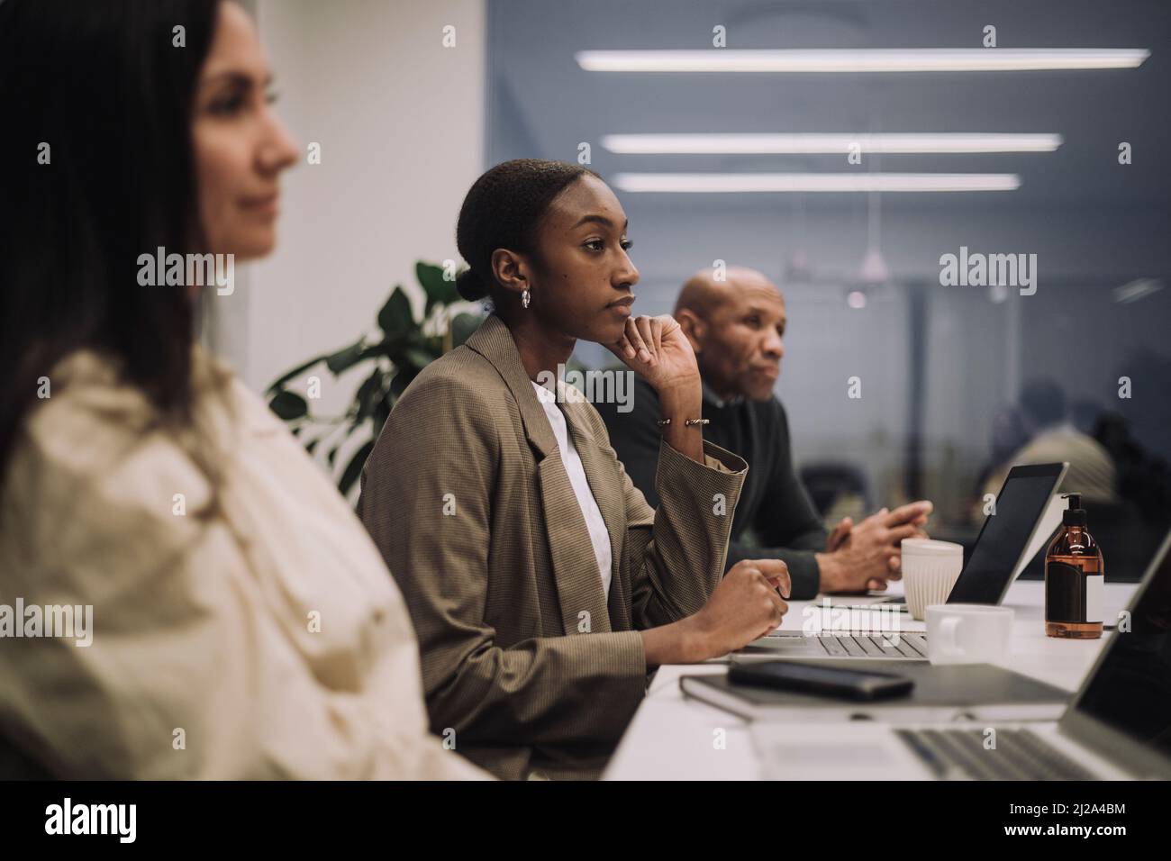 Multiracial male and female business colleagues working with dedication in office Stock Photo
