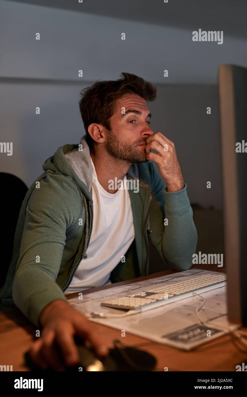 Pulling an all-nighter. Cropped shot of a young designer working late in the office. Stock Photo