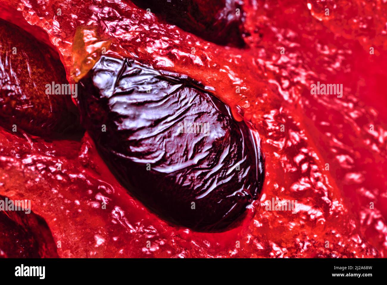 A watermelon (Citrullus vulgaris) seed in a case inside a cut berry-like fruit (multi-seeded juicy pumpkin - pepino). Macro extrem closeup seed Stock Photo