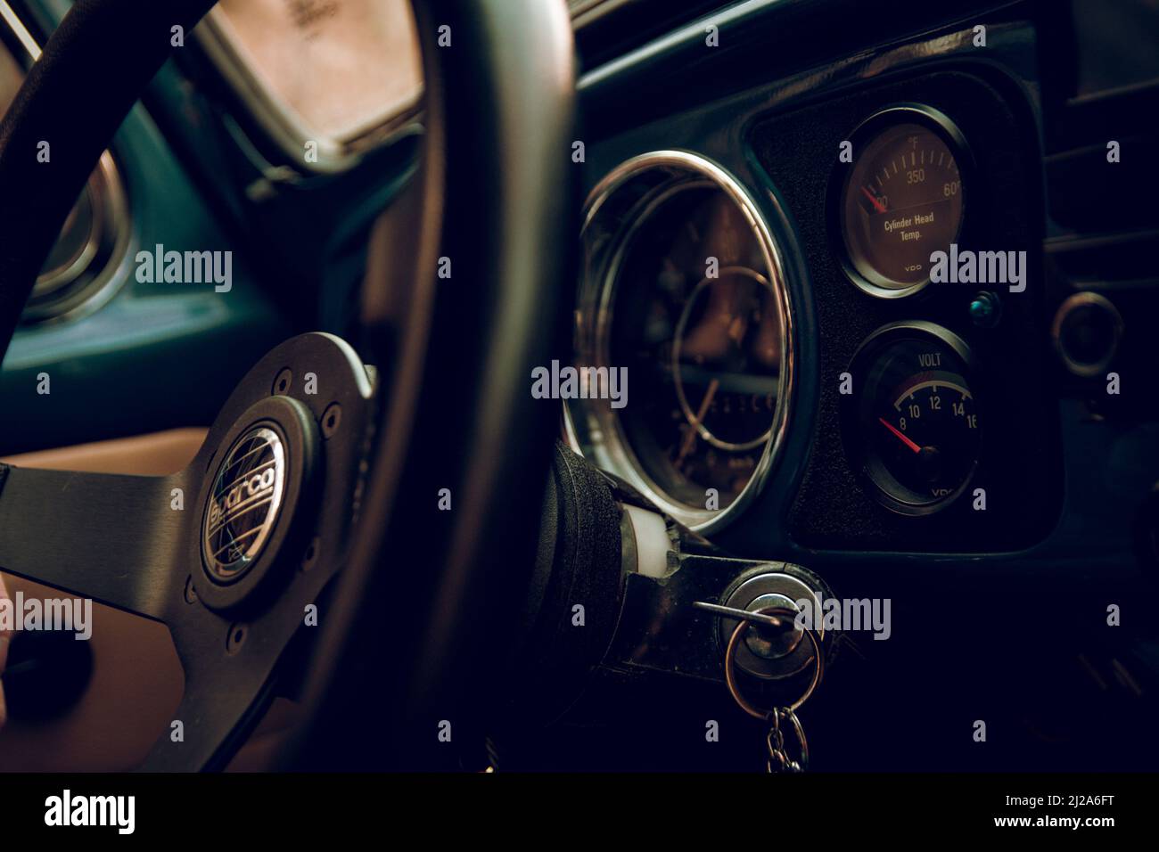 The inside details of a Volkswagen vintage beetle with the streering wheel and car keys on hold Stock Photo