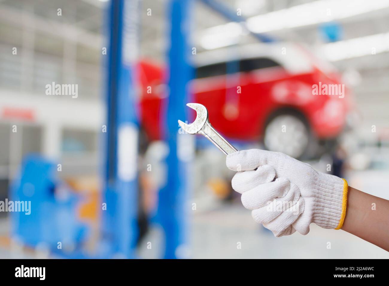 Car mechanic holding wrench at the car repair service garage Stock