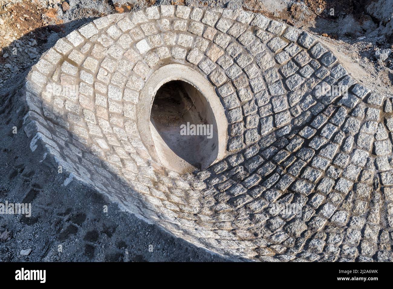 Paved access to a sewer pipe as part of a new bridge's drainage system Stock Photo