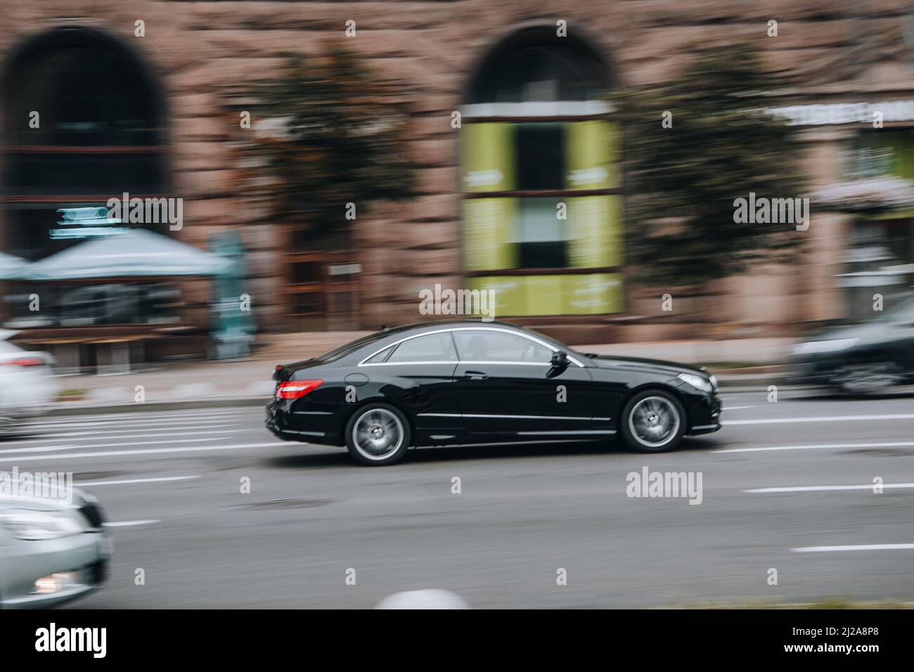 Ukraine, Kyiv - 2 August 2021: Black Mercedes-Benz E-Class car moving on the street. Editorial Stock Photo