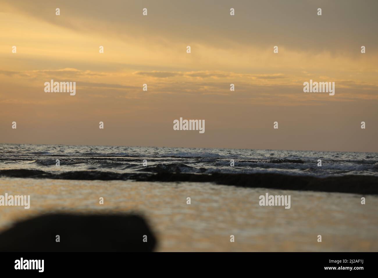 Sea landscape. Surfline with waves and foam at sunset time. Nature background Stock Photo