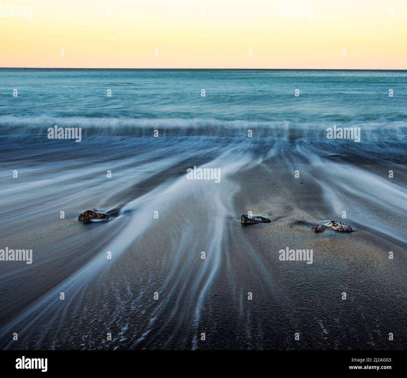 Isshiki Beach at low tide creates great opportunities for long-exposure photography as the waves slowly recede back into the ocean leaving behind trai Stock Photo