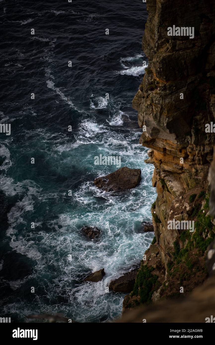 A vertical bird's eye view of waves hitting the rocks Stock Photo - Alamy