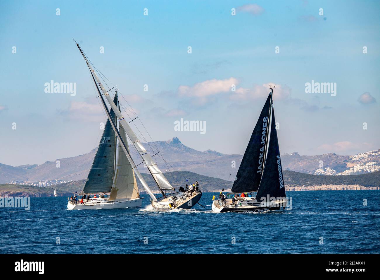 Bodrum, Mugla, Turkey - 02.25.2022: Coalition on sea. Sailing team racing at regatta. Navigation with open sails. Accident and disaster protection. Stock Photo