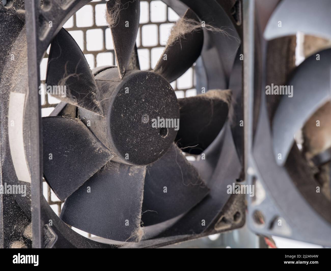 A dusty fan in a computer case. Close up. Stock Photo