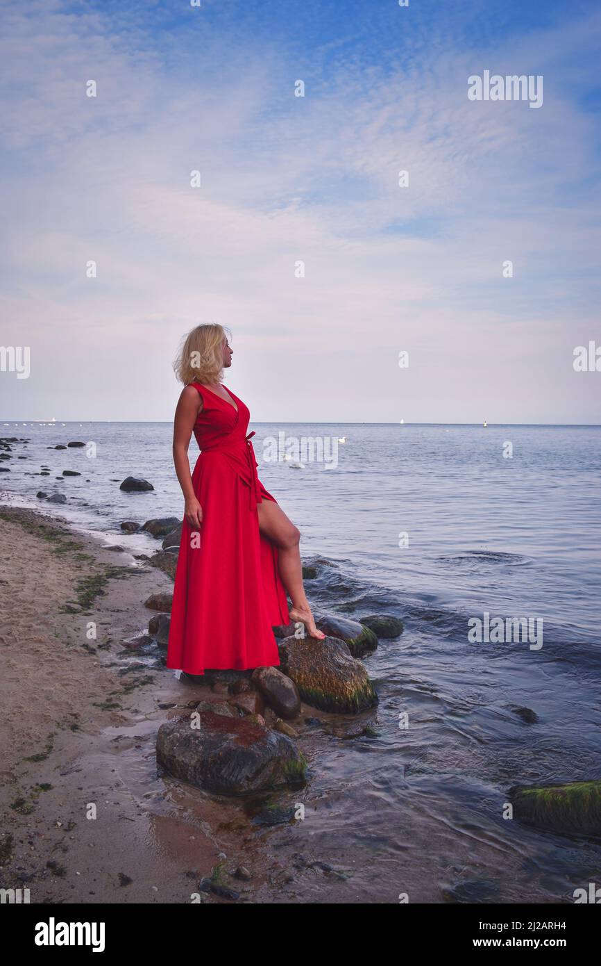 Summer concept with a beautiful woman. The blonde haired girl on the shore of the Polish sea. Stock Photo