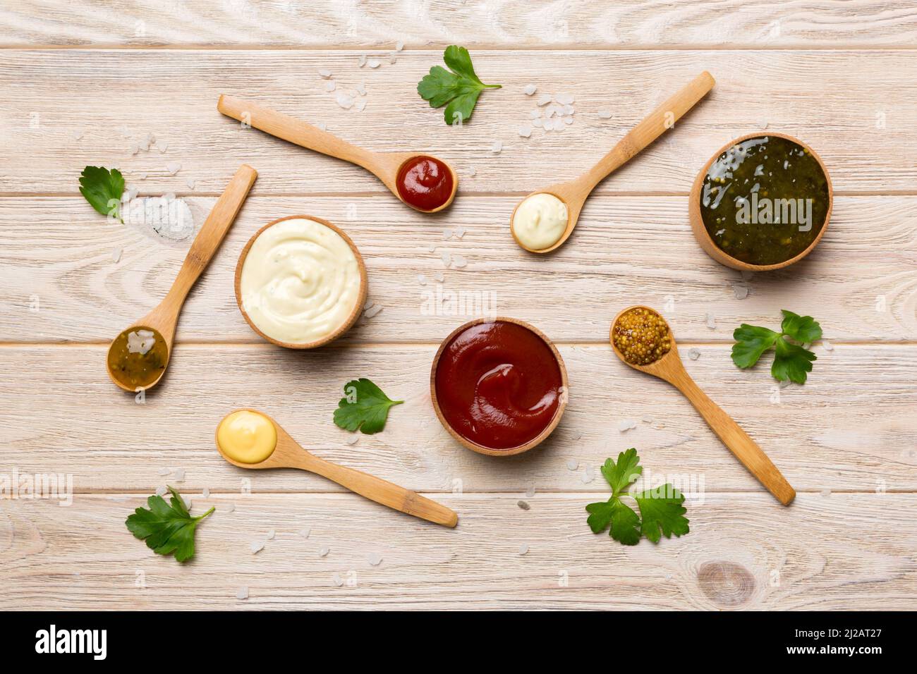 Different sauces in spoons on table background, flat lay top view. Stock Photo