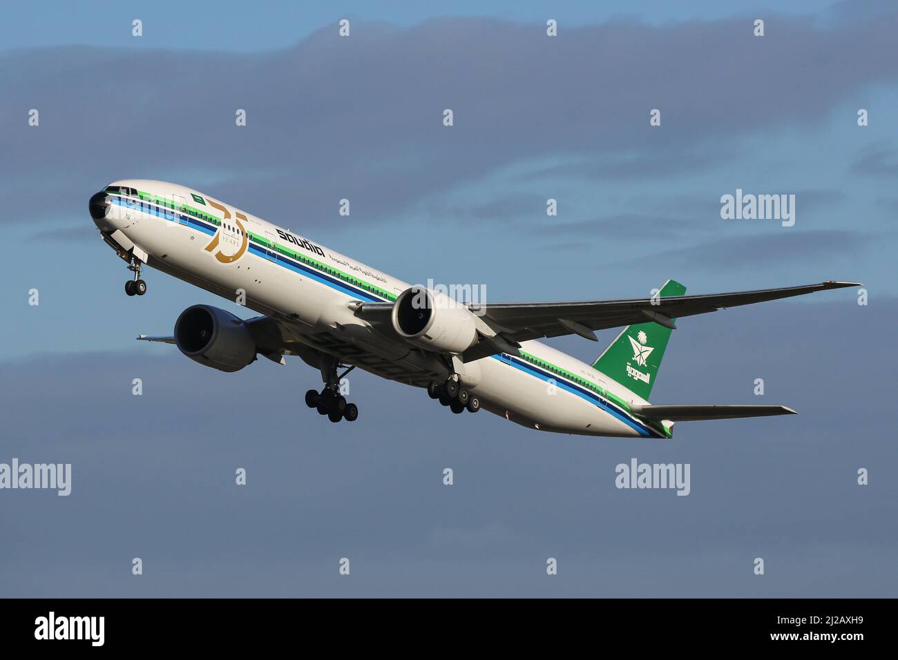 A Boeing 777 operated by Saudia, wearing a special Retro Livery, departs from London Heathrow Airport Stock Photo