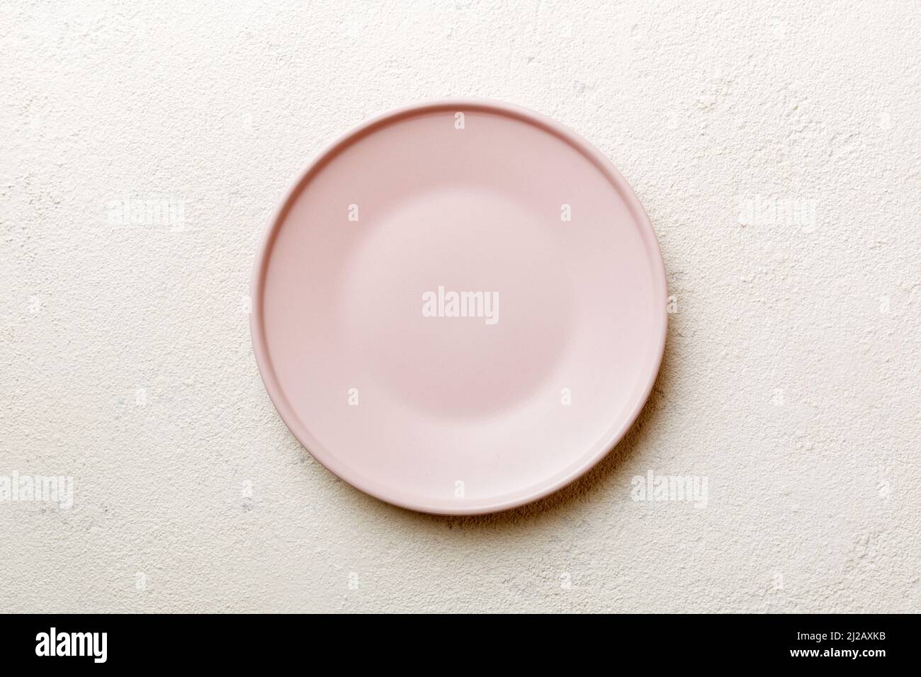 Top view of empty pink plate on cement background. Empty space for your ...